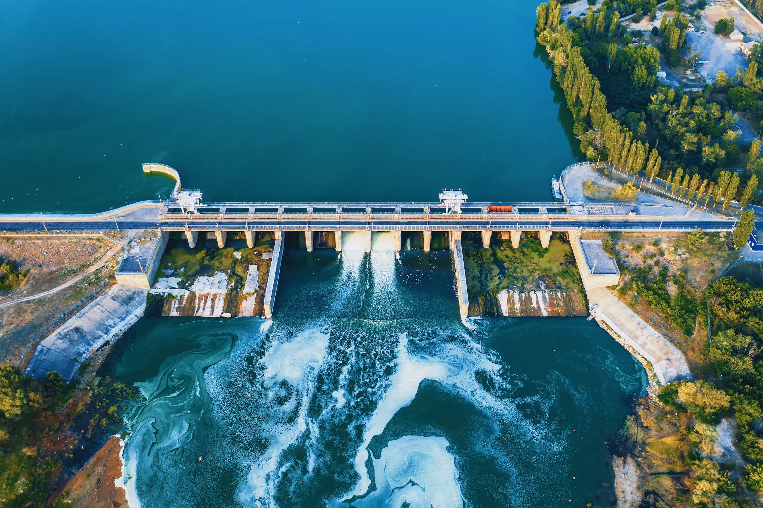 Overhead view of a large reservoir dam and spillway construction representing USACE water infrastructure programs.